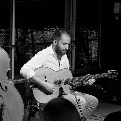 Three musicians performing live jazz on stage in a club setting, featuring two acoustic guitar players and an upright bassist, with a 'Jazz Club' sign visible in the background.